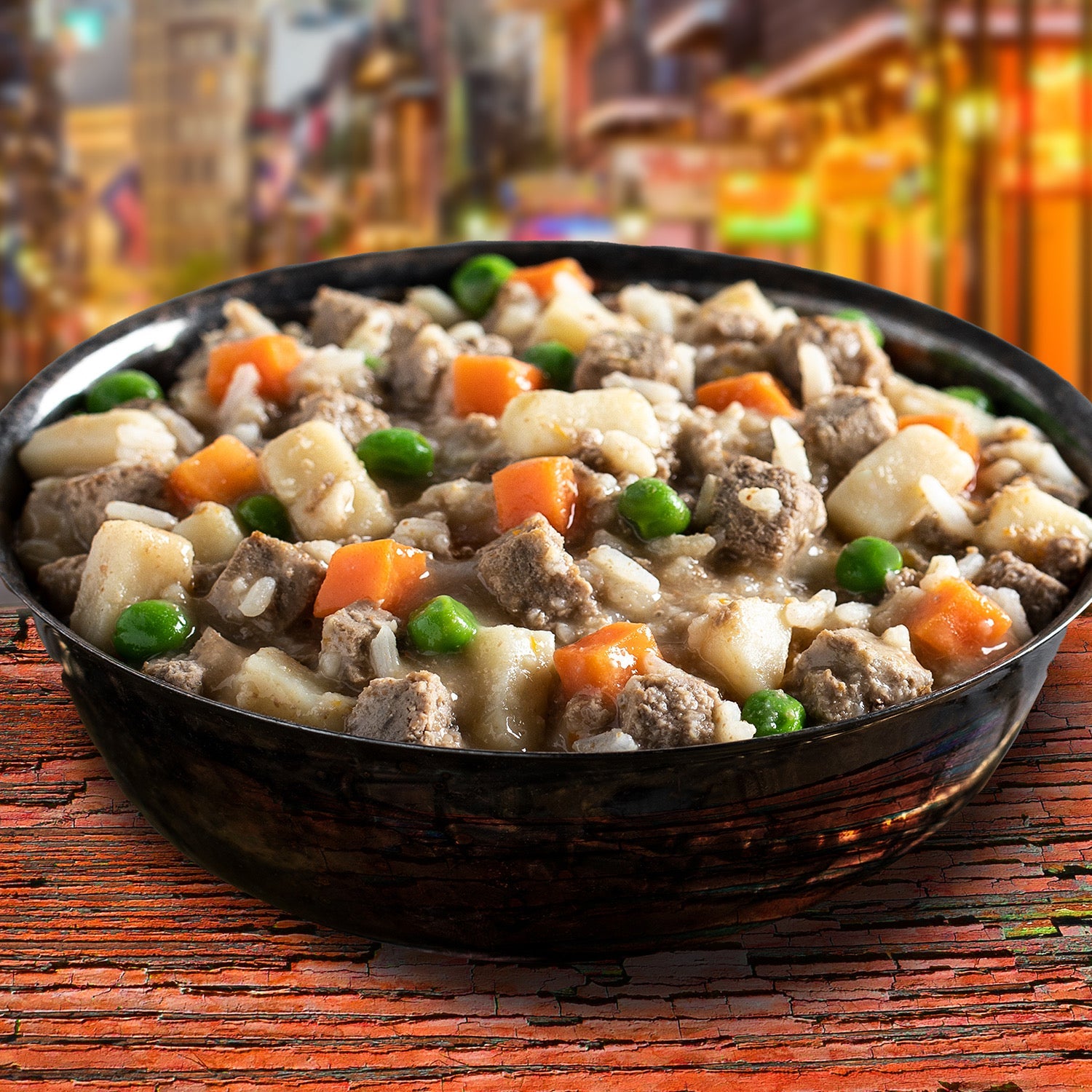 A bowl of Fromm Frommbalaya chicken stew with rice, carrots, and peas before a colorful New Orleans street scene
