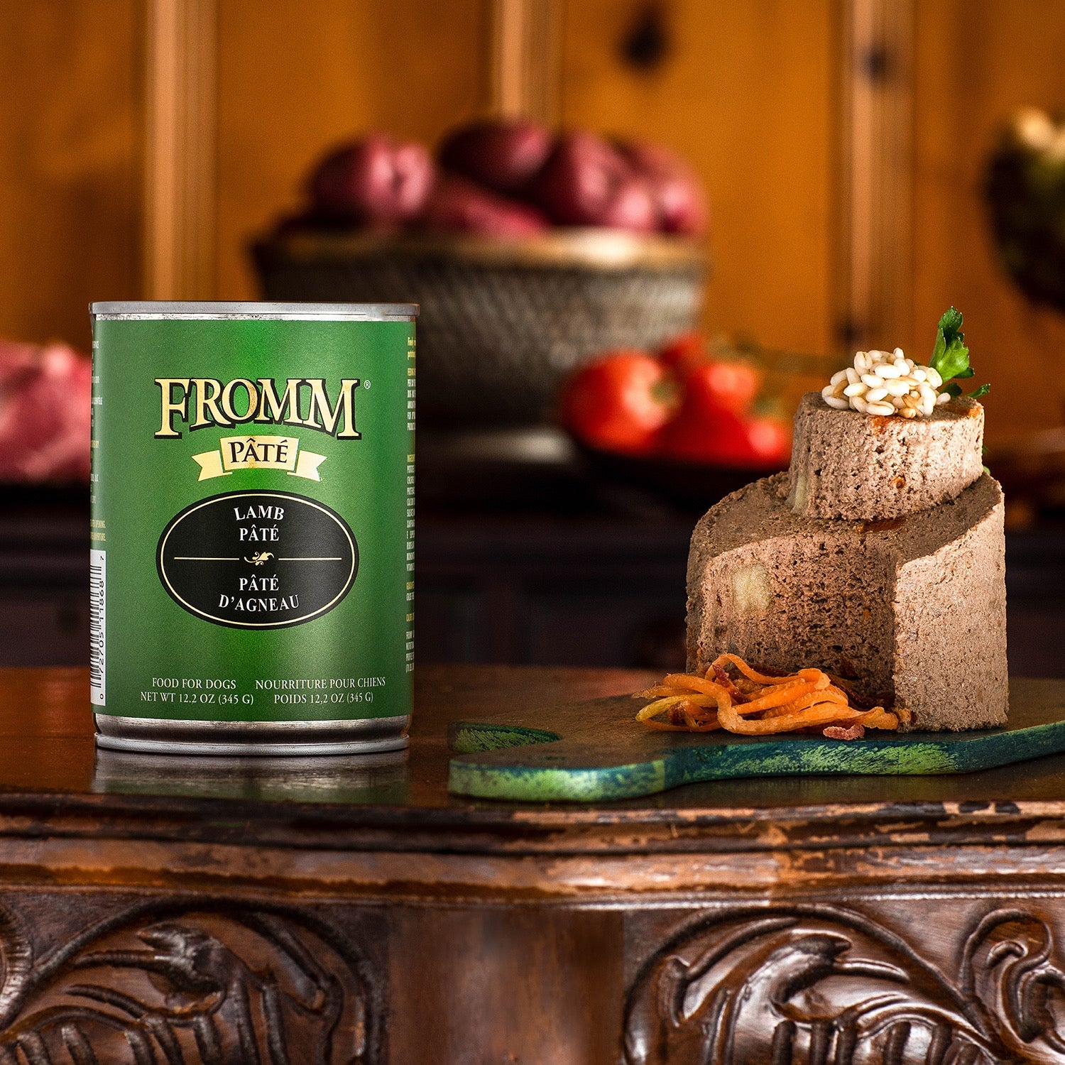 A can of Fromm Pâté Lamb Pâté beside a plated pâté portion on a carved wooden board