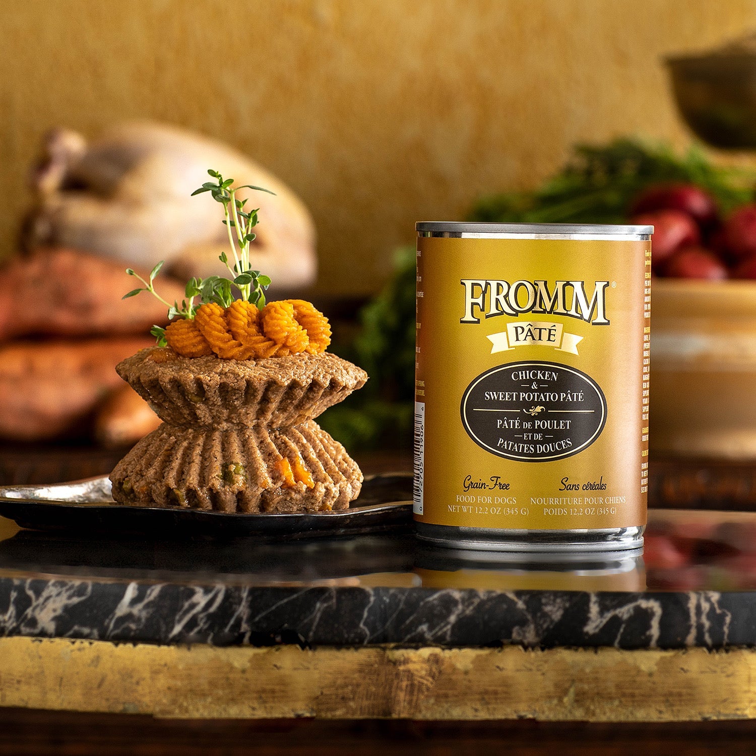A can of Fromm Pâté Chicken & Sweet Potato beside plated pâté topped with piped sweet potato and fresh thyme