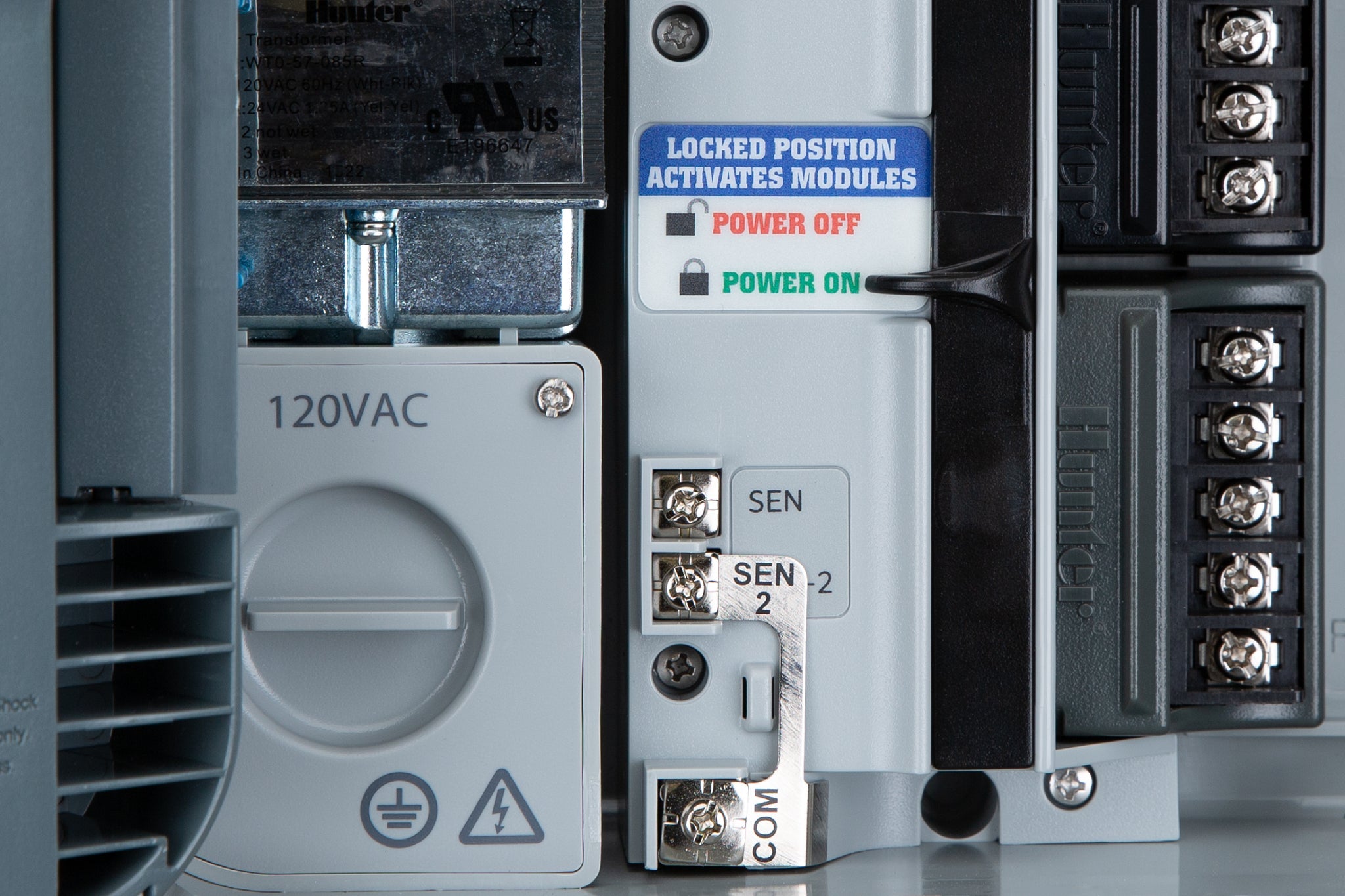 Hunter P2C-400 Pro-C controller wiring detail closeup showing the LOCKED POSITION ACTIVATES MODULES lever, 120 VAC junction box, sensor terminals SEN and SEN-2, and station terminal strips