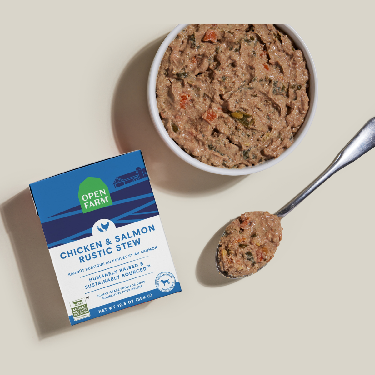 Open Farm Chicken & Salmon Rustic Stew Wet Dog Food -- 12.5 oz carton beside a bowl of food