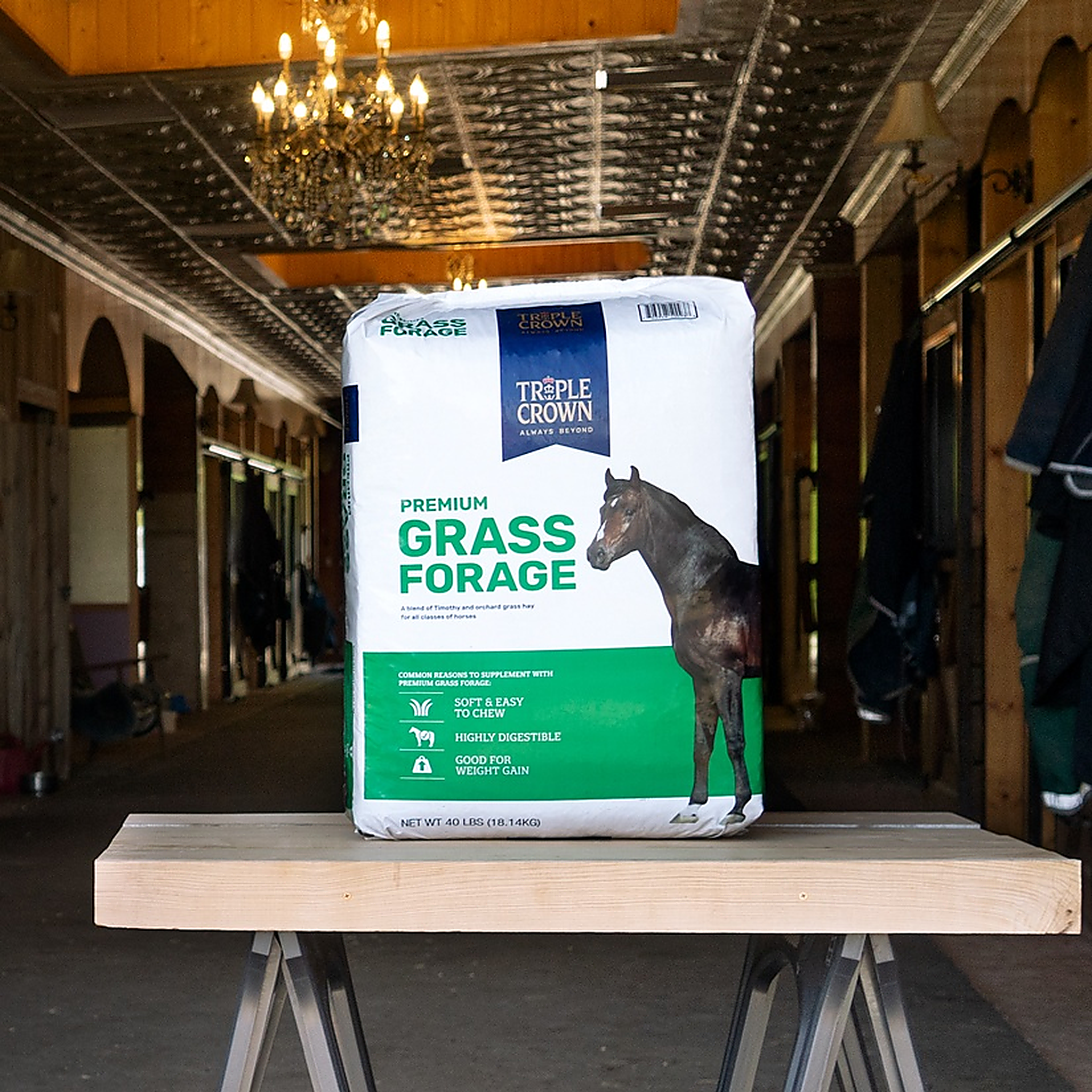 Triple Crown Premium Grass Forage 40 lb bag on a table in a barn aisle