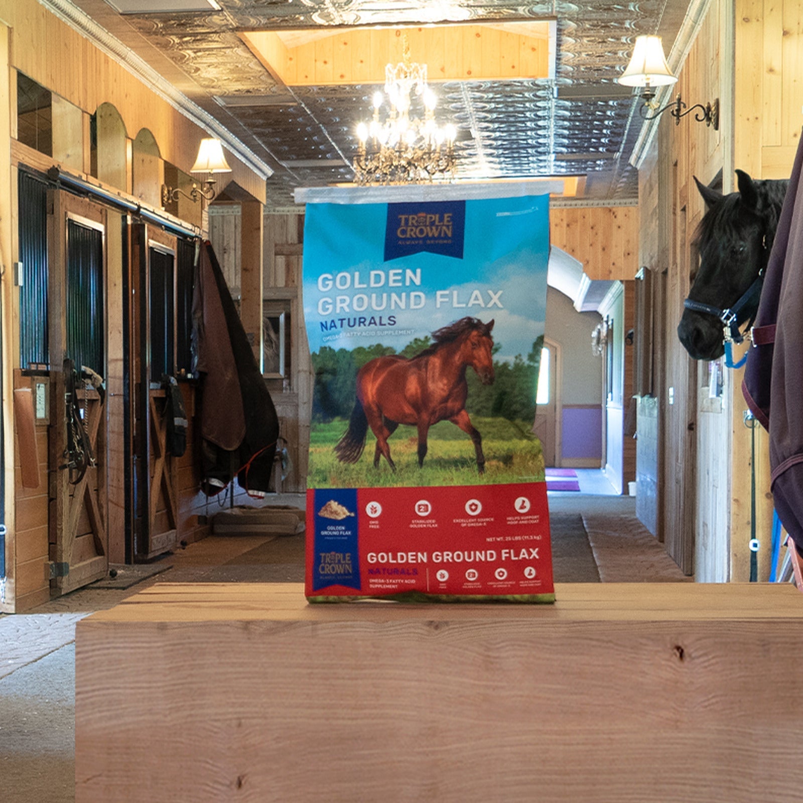 Triple Crown Naturals Golden Ground Flax bag on a beam in a stable aisle