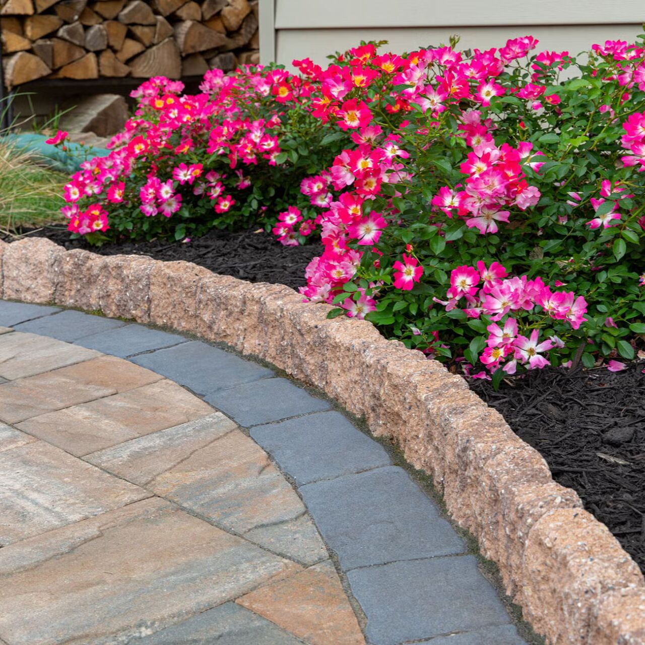 Belgard Edgestone Edger edging a mulched flower bed with roses