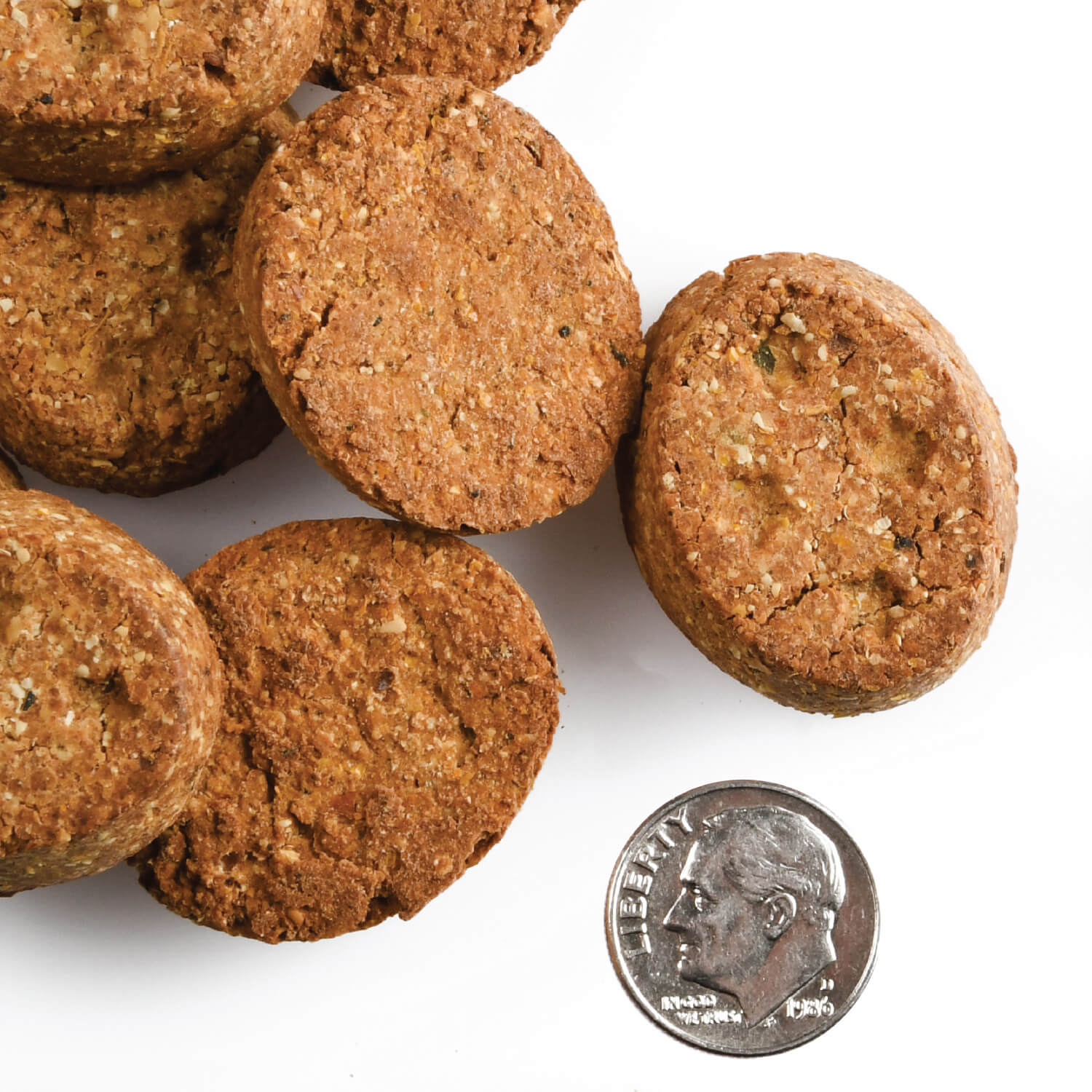 Oven-baked Fromm Four-Star Chicken with Peas and Carrots treats shown with a dime for scale
