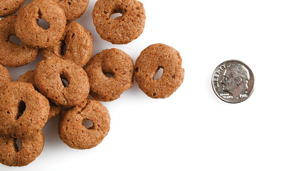 Fromm Crunchy O's treats out of the package next to a dime for scale