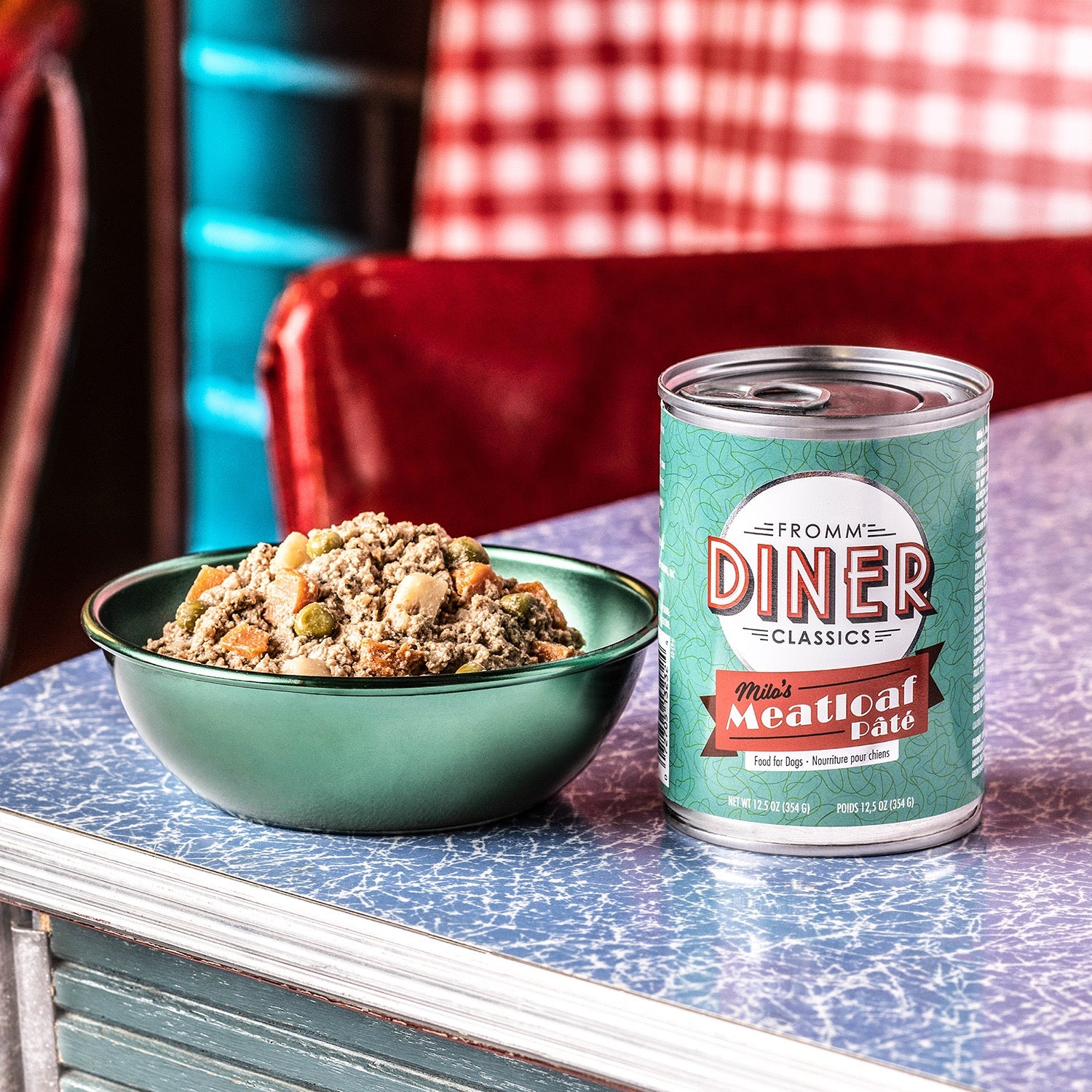 A can of Fromm Diner Classics Milo's Meatloaf Pâté beside a bowl of the food on a retro diner table