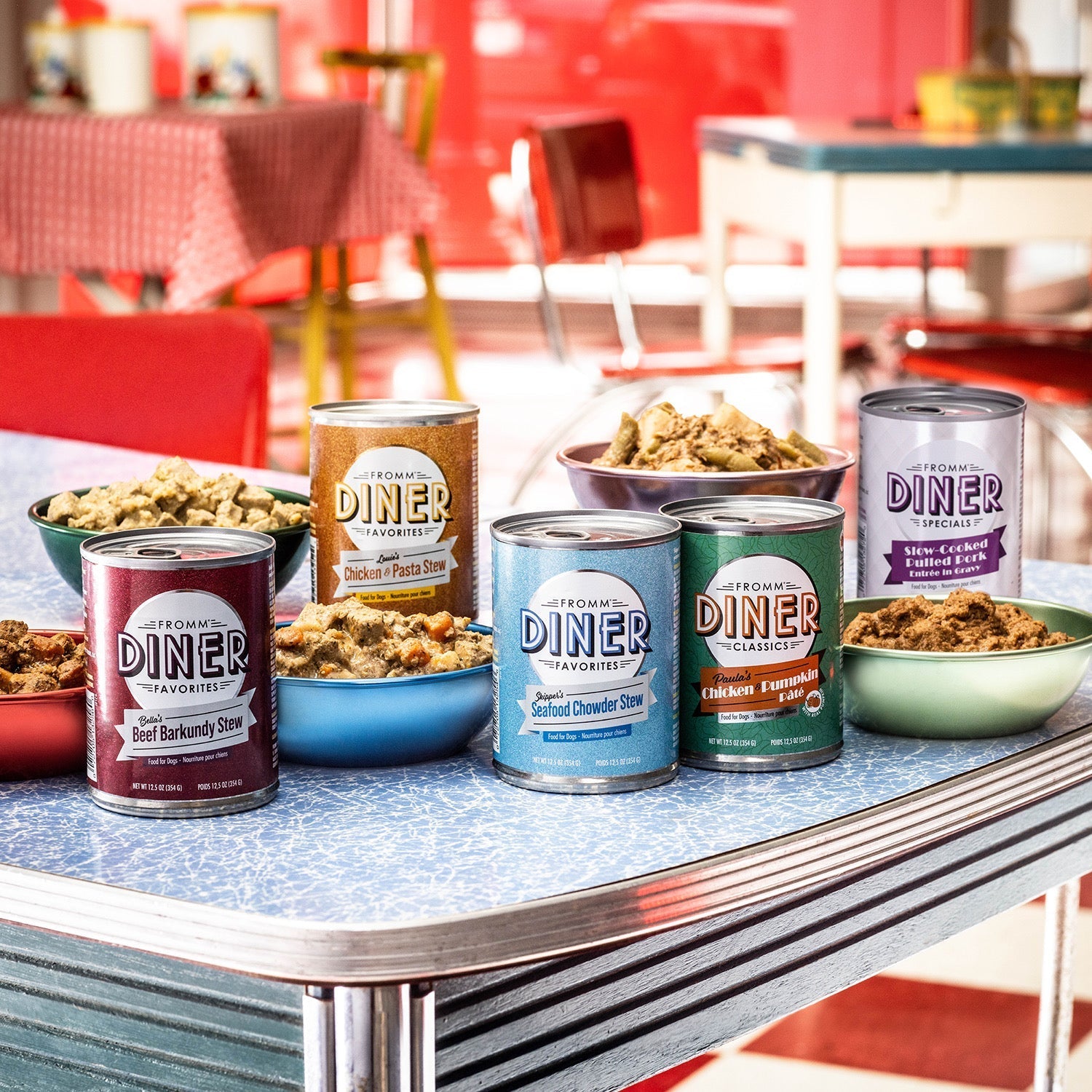 Fromm Diner canned entrée cans and filled bowls on a retro diner table