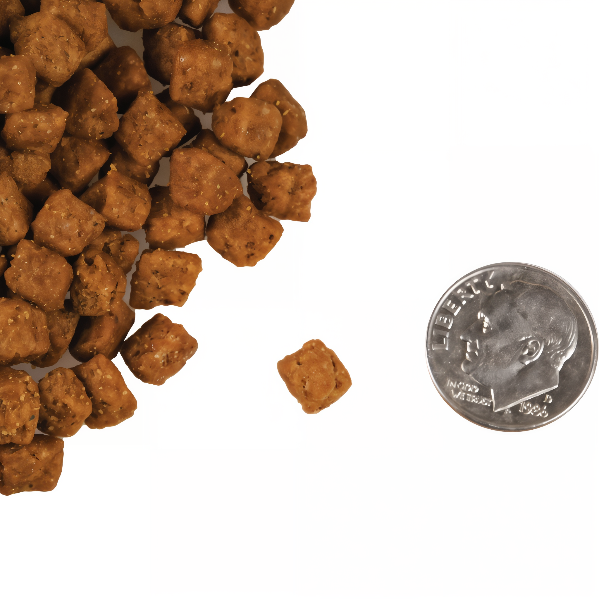 A small pile of cube-shaped Fromm Four-Star Beef Liváttini Veg kibble next to a dime for scale