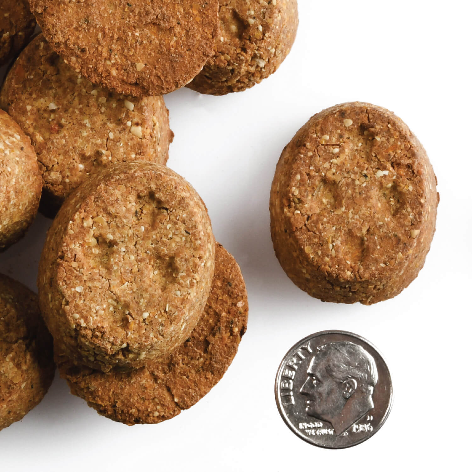 Oven-baked Fromm parmesan cheese treats shown beside a US dime for size comparison