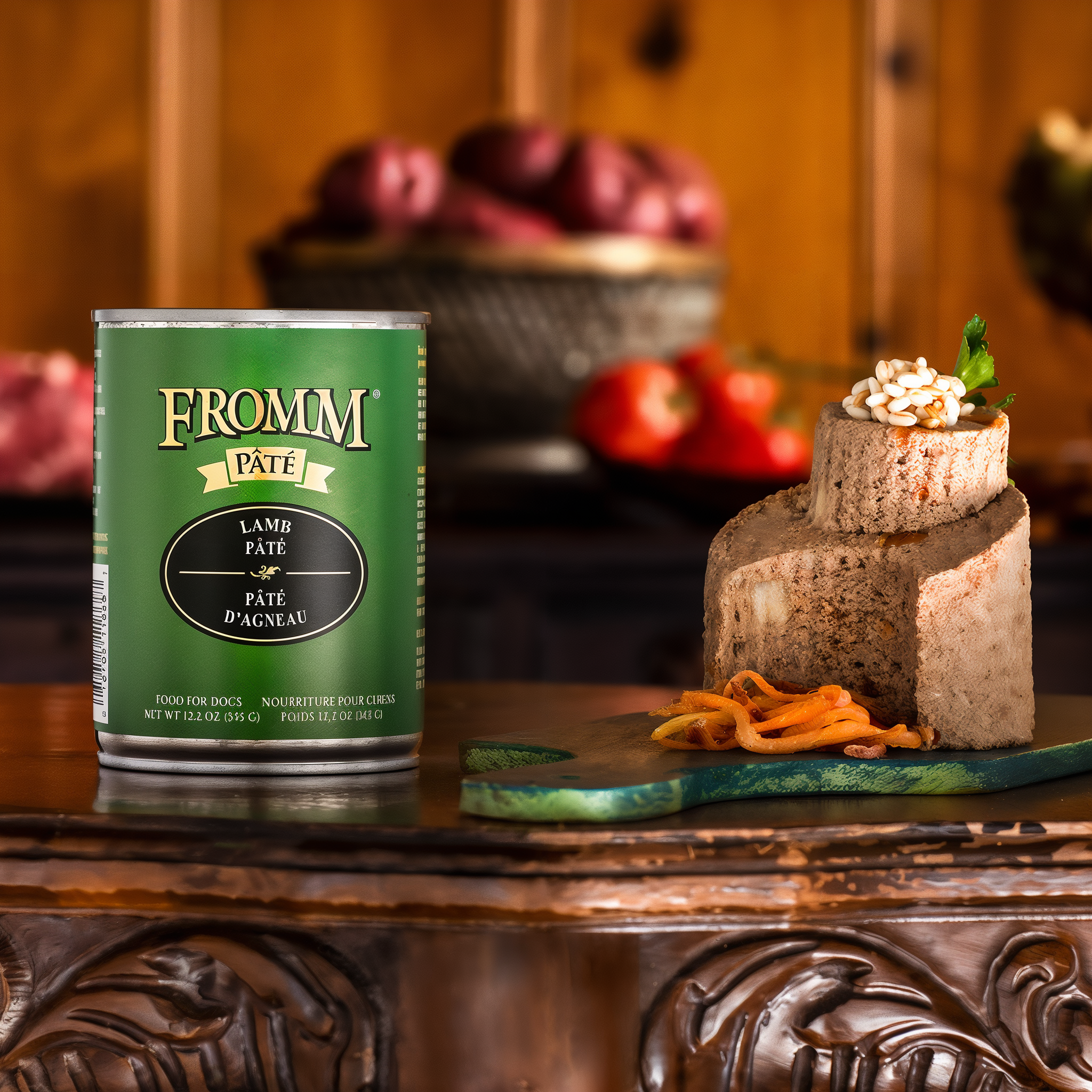 A can of Fromm Pâté Lamb Pâté beside a plated pâté portion on a carved wooden board