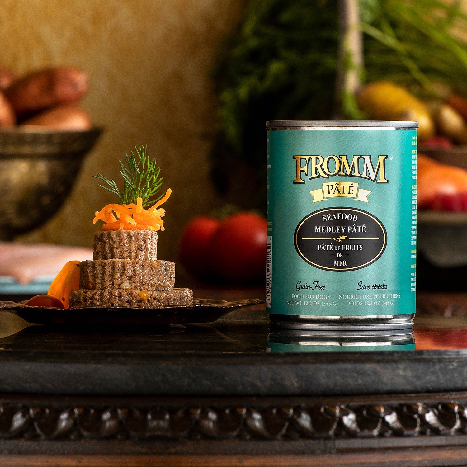 A can of Fromm Pâté Seafood Medley beside a plated pâté stack topped with shredded carrot and fresh dill