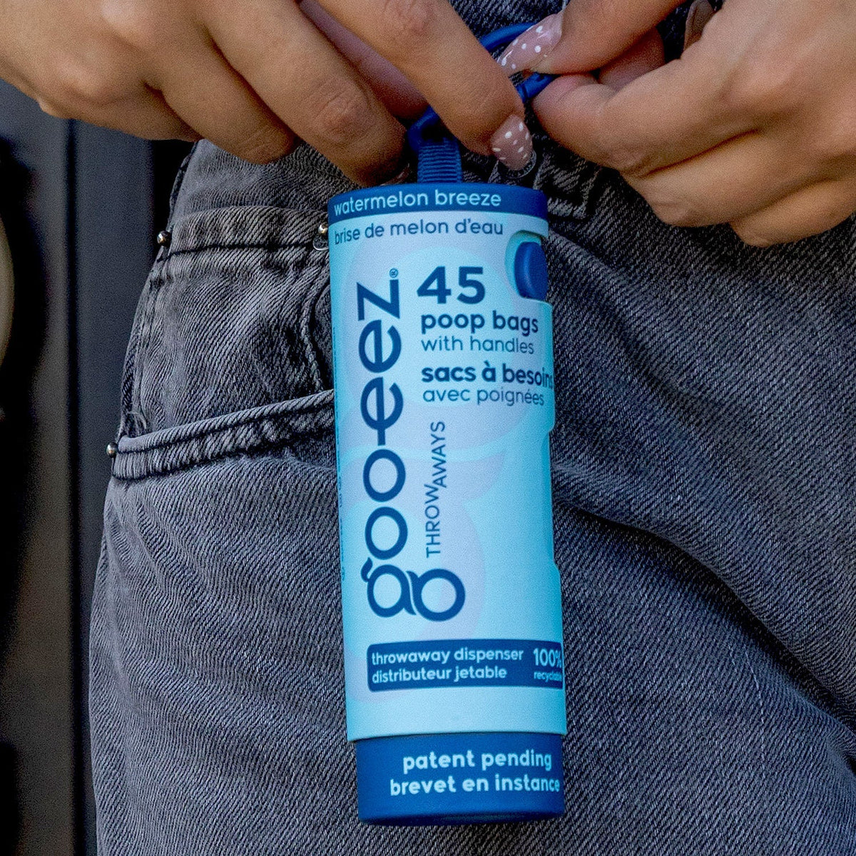 Pulling a handle bag from a Goo-eez Throwaways dispenser clipped to a bag
