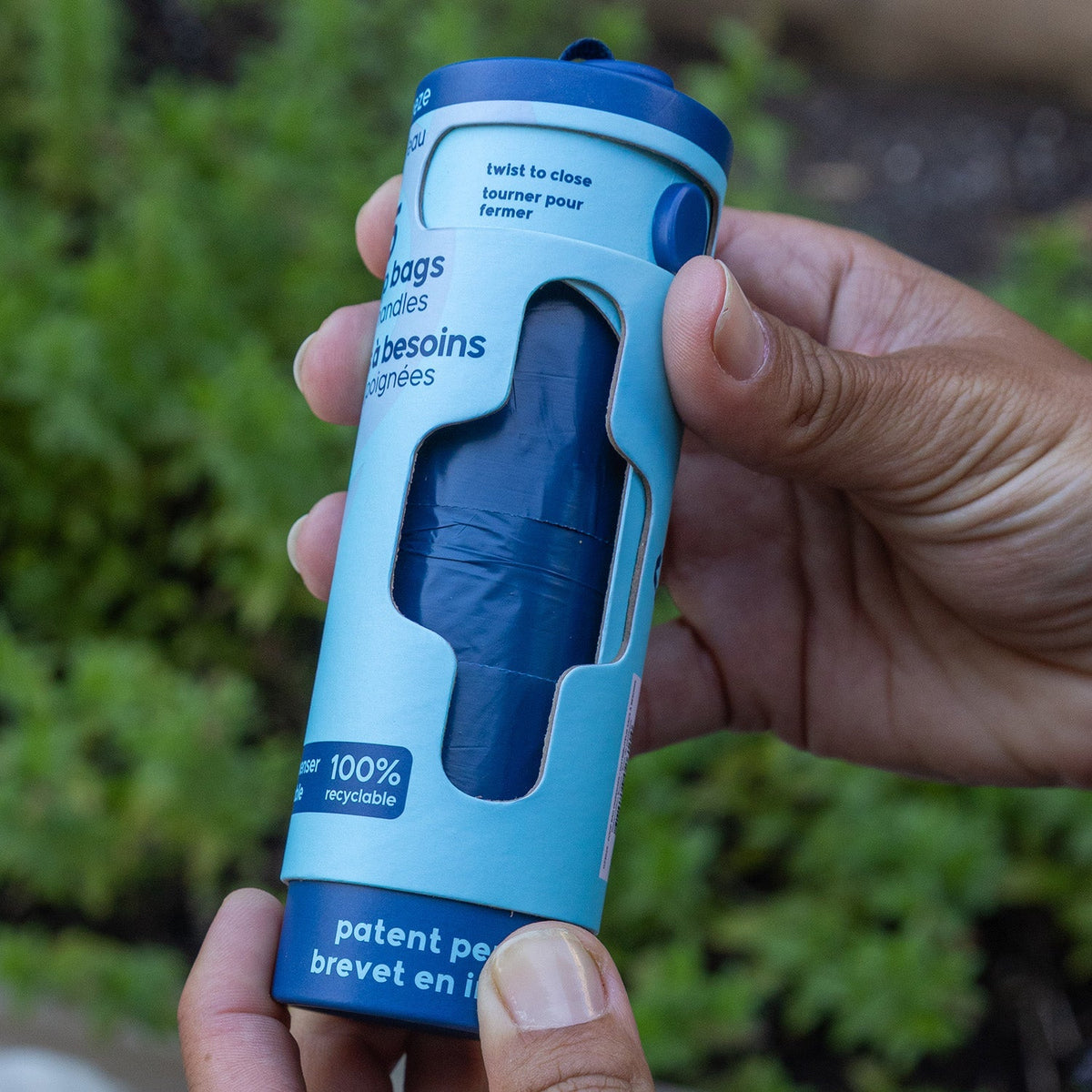 Hand twisting open the bottom of a Goo-eez Throwaways dispenser