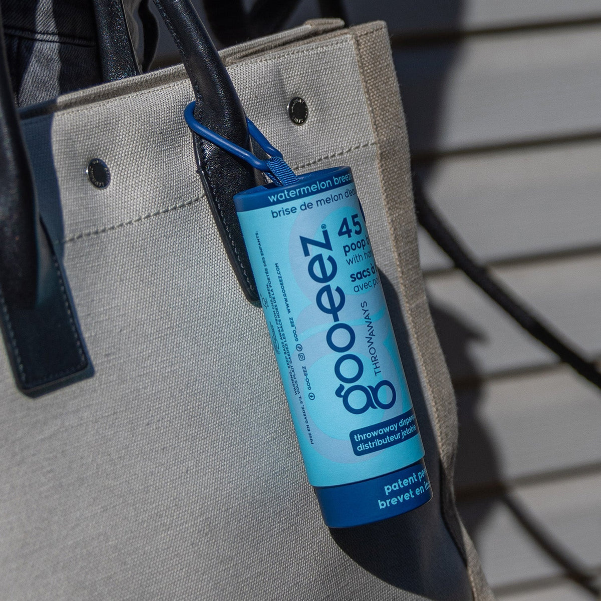 Watermelon Breeze Goo-eez Throwaways dispenser clipped to a tote bag
