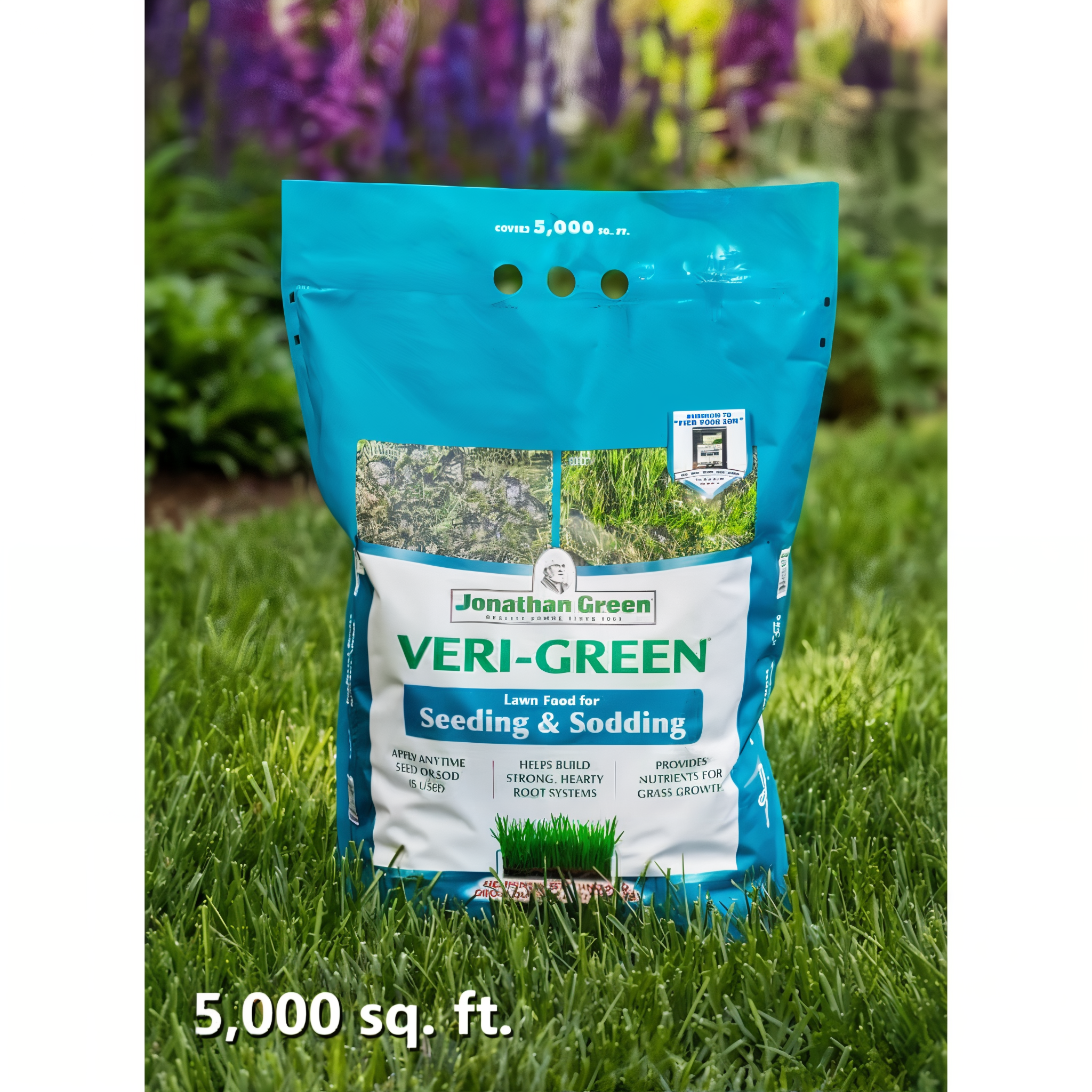 Jonathan Green Veri-Green Starter Fertilizer 15 lb bag covering 5,000 sq ft, standing on a lush green lawn with flowers, 12-18-8 starter lawn food for seeding and sodding