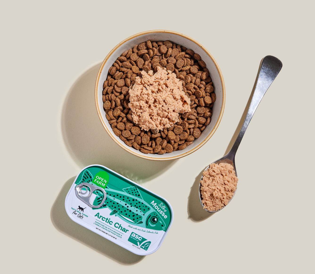 Open Farm Arctic Char Topper served over kibble in a bowl with a spoon