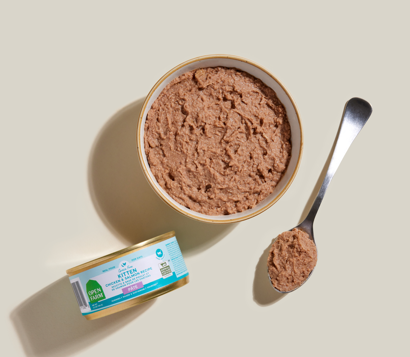 Open Farm kitten chicken and salmon pâté served in a bowl beside the can and a spoon