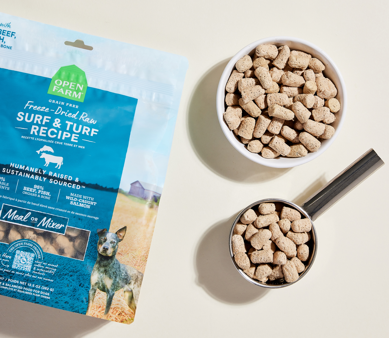Open Farm Surf & Turf freeze dried morsels in a bowl and measuring scoop