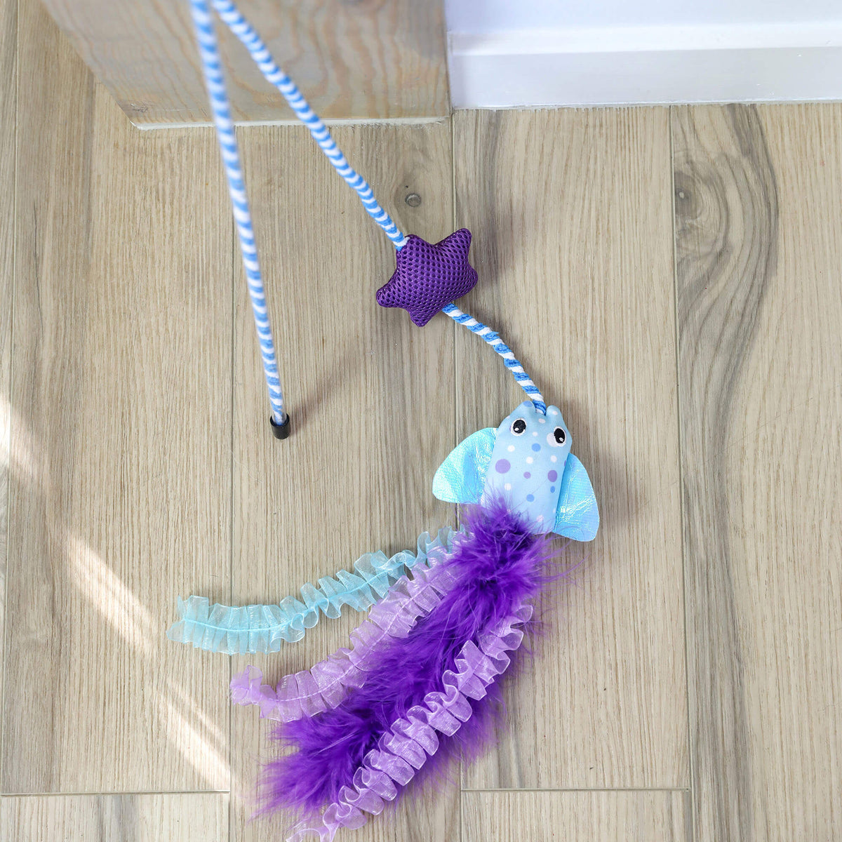 Quirky Kitty Manta Ray Wand resting on a light wood floor