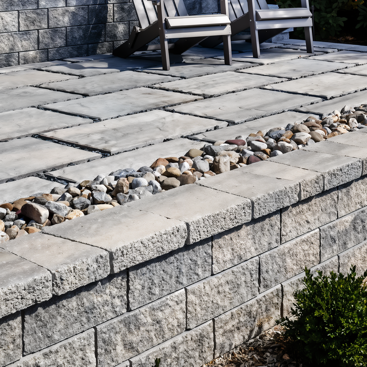 Architectural Cap in Shale Grey tops a garden wall beside ri.