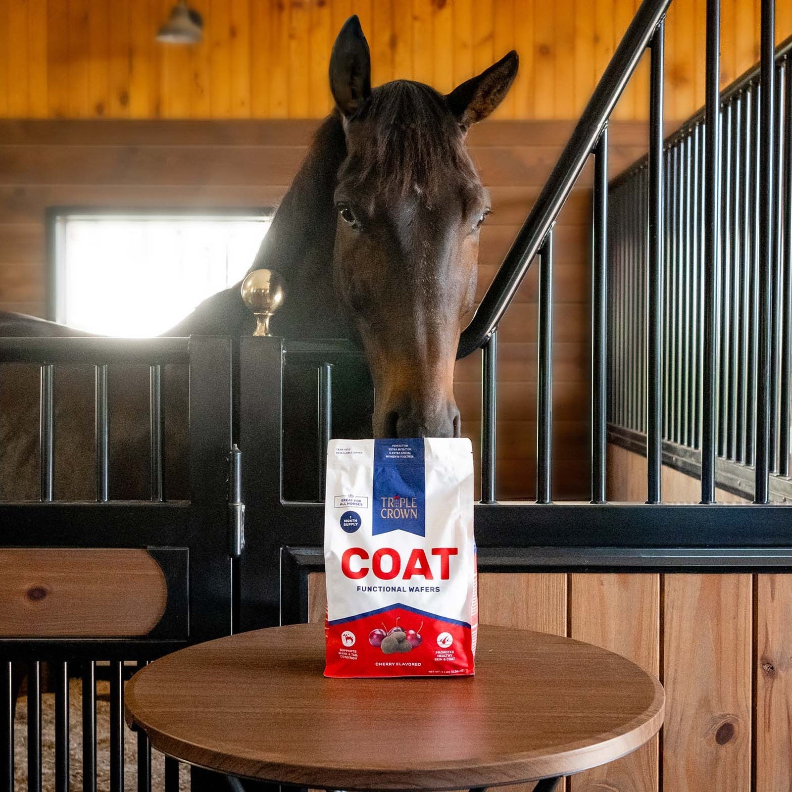 Triple Crown Coat Functional Wafers pouch on a table with a bay horse reaching over the stall door
