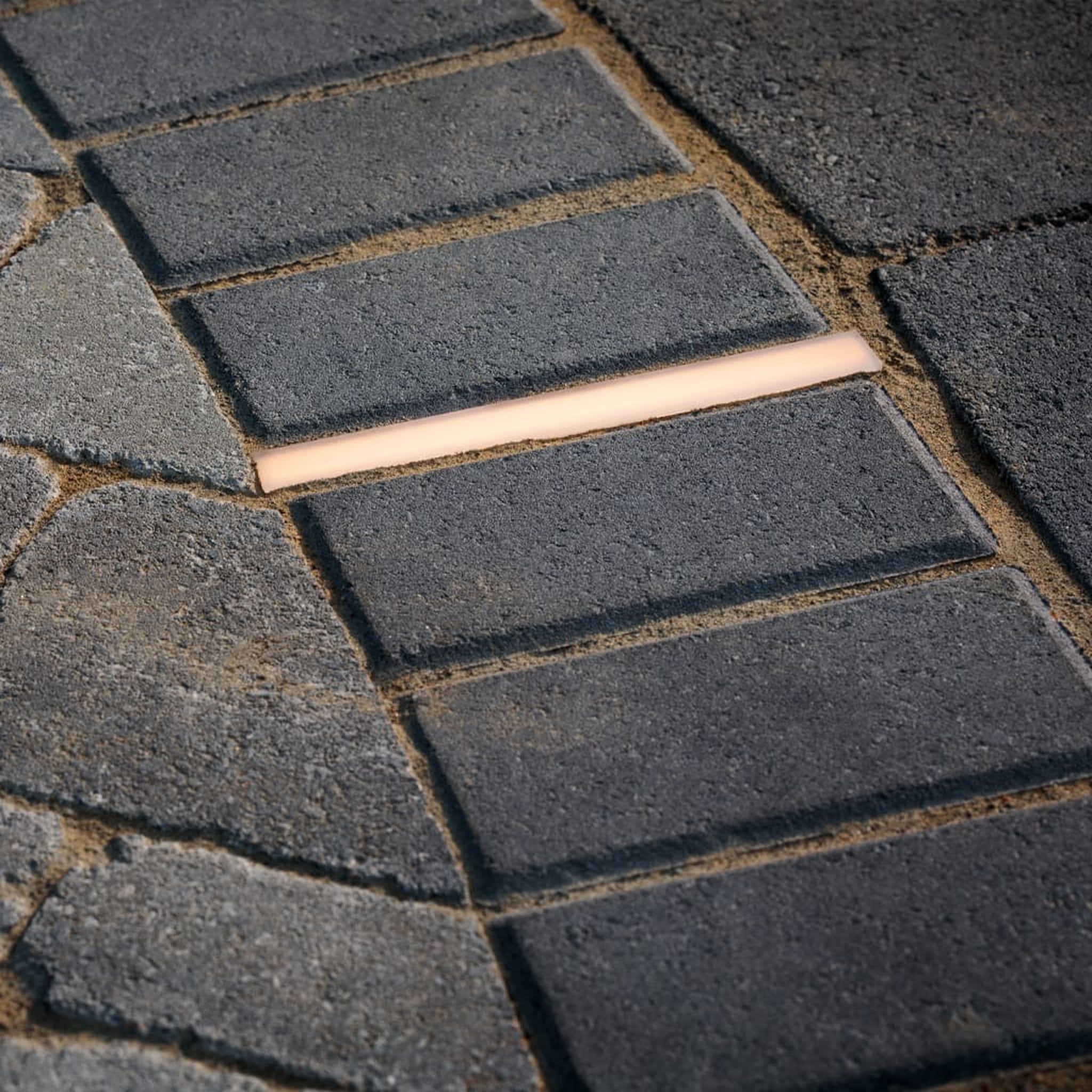 Tru-Scapes Traditional Paver Light HPL Series installed in a hardscape wall — landscape lighting at dusk